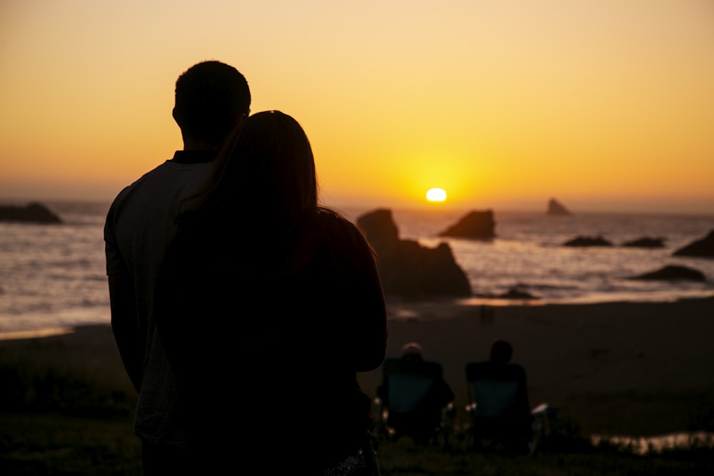 man and woman sitting on shore