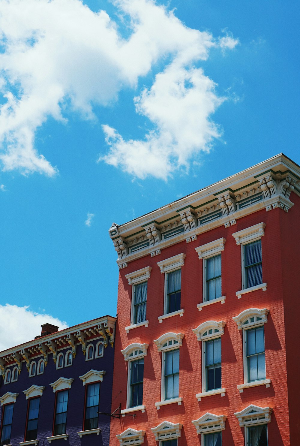 푸른 하늘을 가로 지르는 빨간색과 흰색 아파트 건물