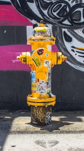 yellow fire hydrant near wall
