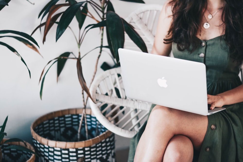 woman sitting and using MacBook