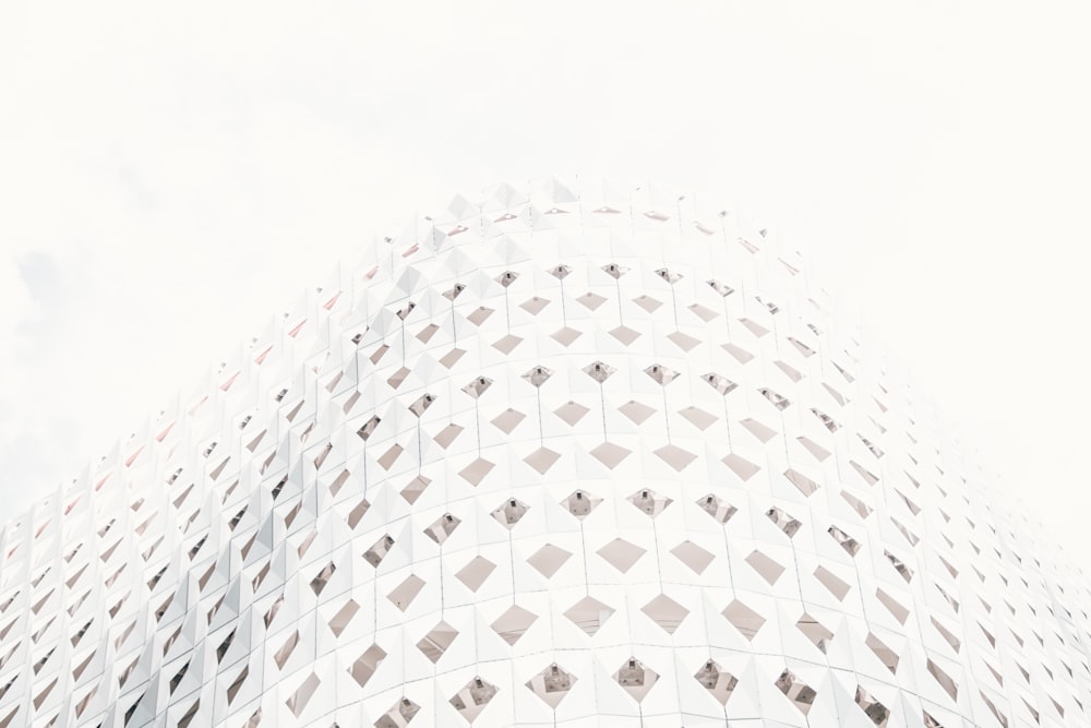 a tall white building with a sky in the background