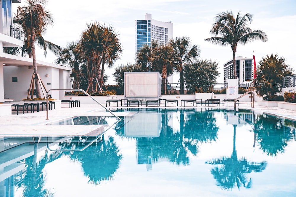 white concrete pavement beside pool during daytime