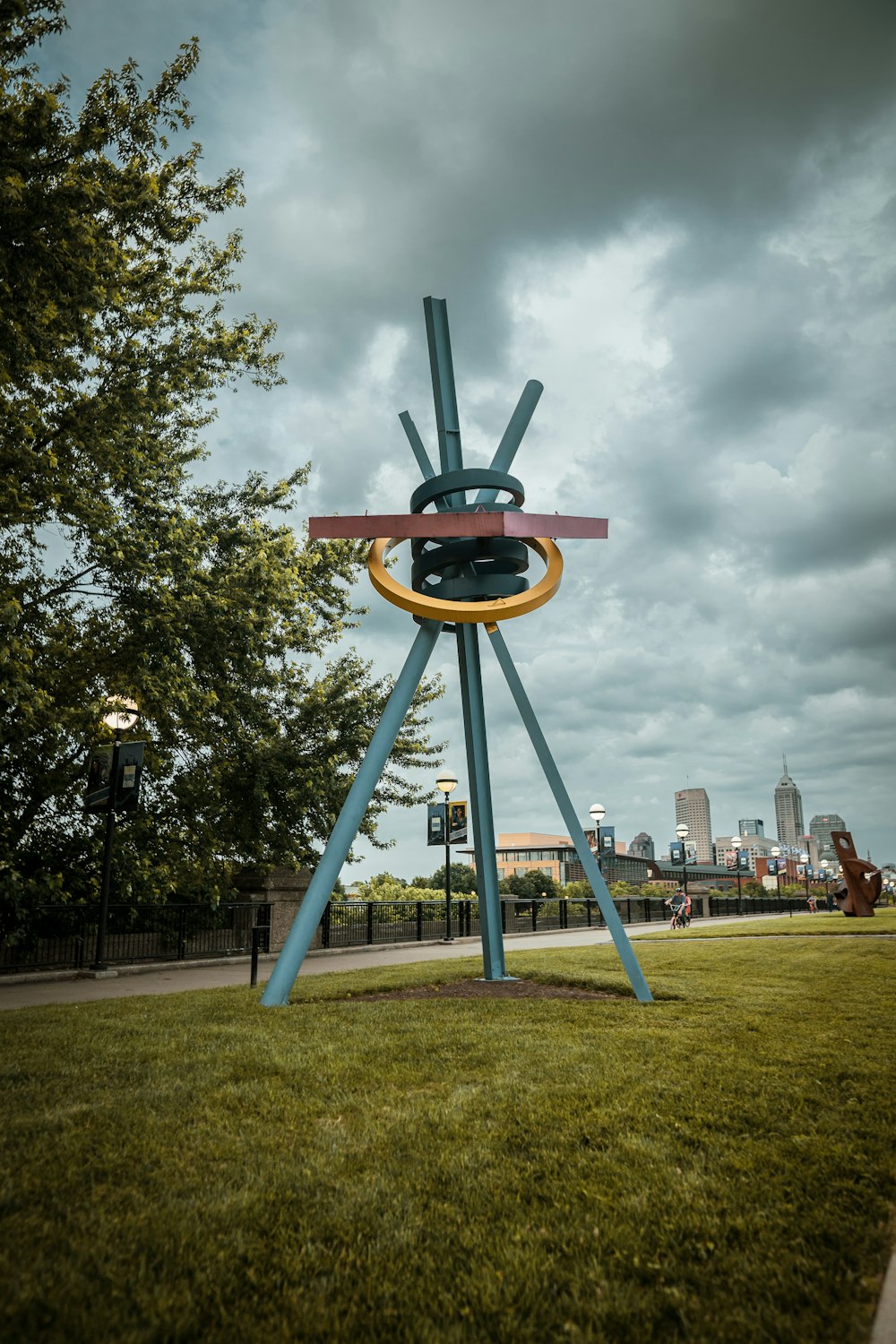 blue tripod statue near green tree