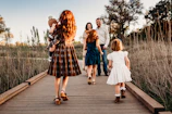 A cinematic shot of a family walking hand-in-hand along a sun-drenched path.