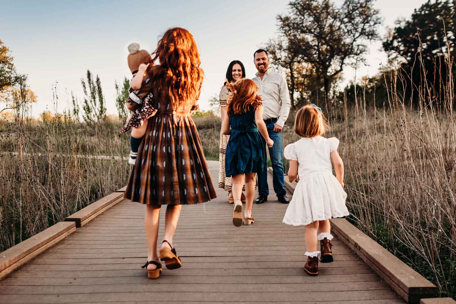 A family walking along a boardwalk at golden hour