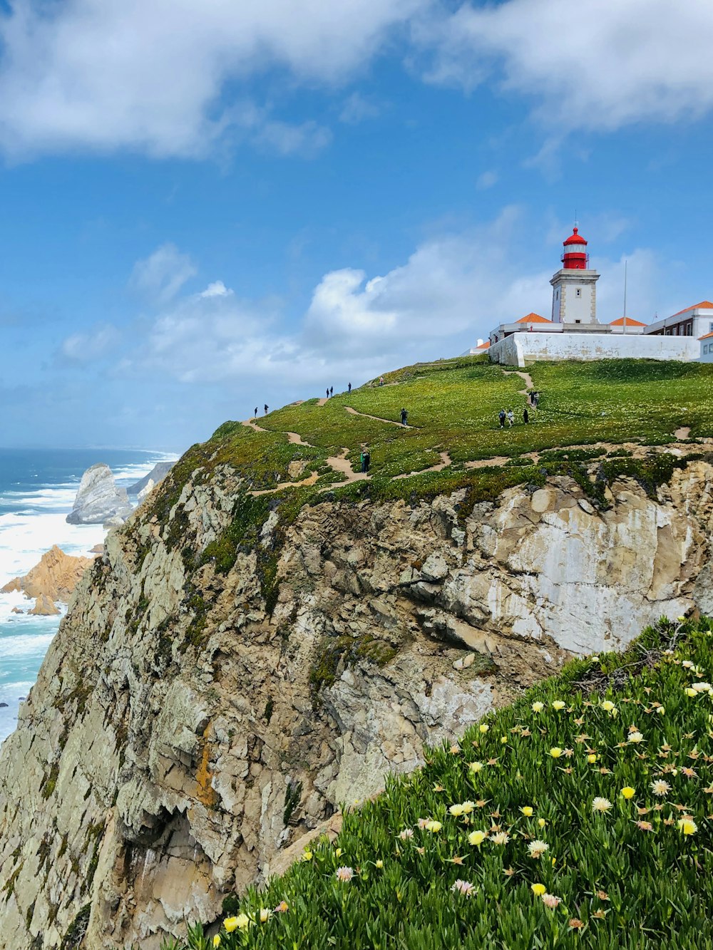 lighthouse tower on top of mountain near ocean