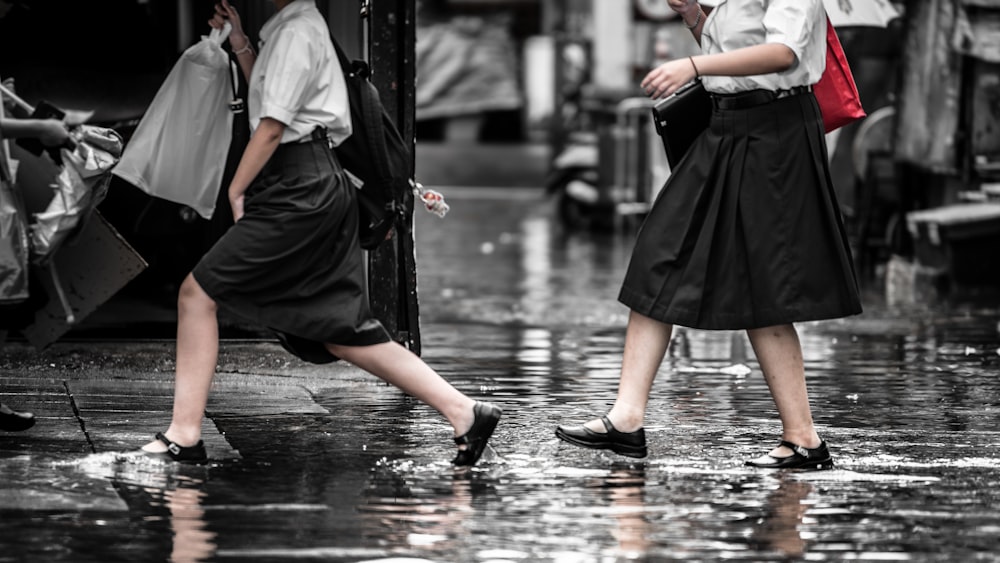 two women walking on wet ground