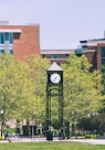 gray clock tower near trees during daytime
