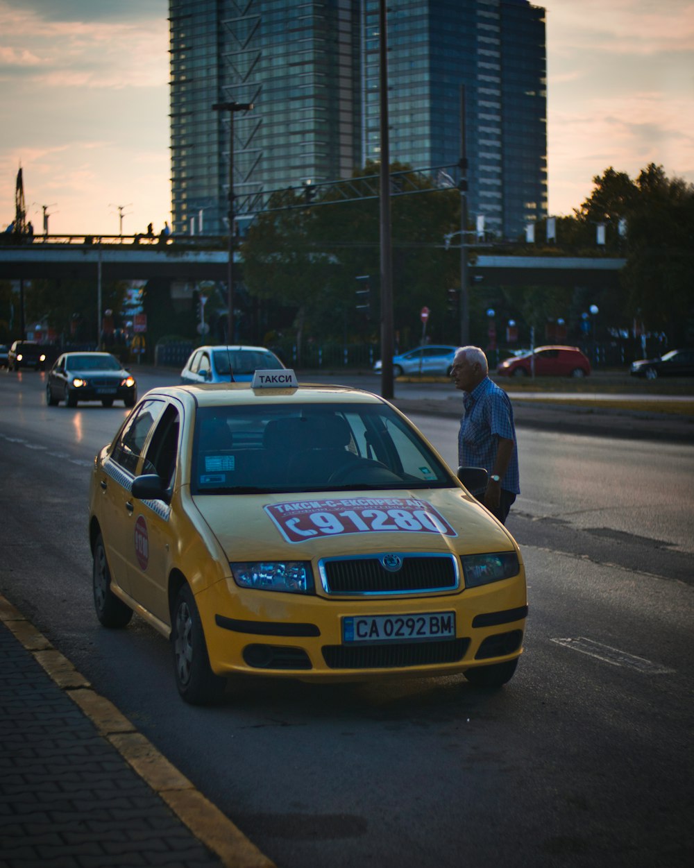 man standing beside taxi