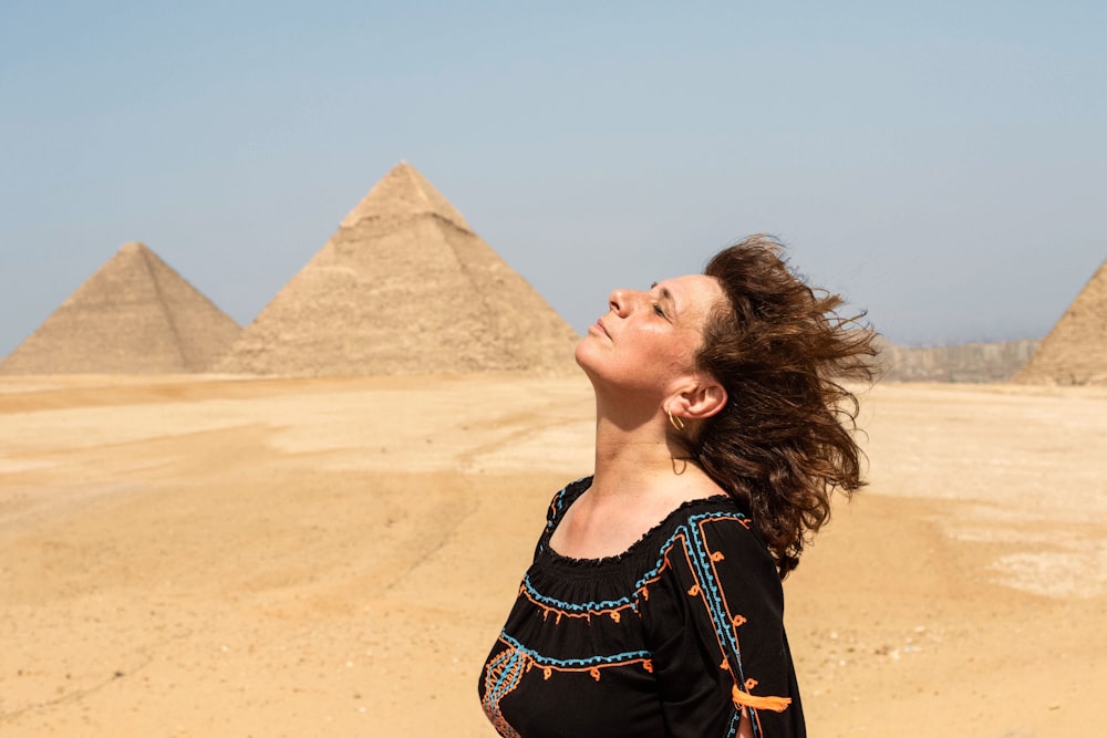 woman in black and blue crew-neck shirt near pyramids