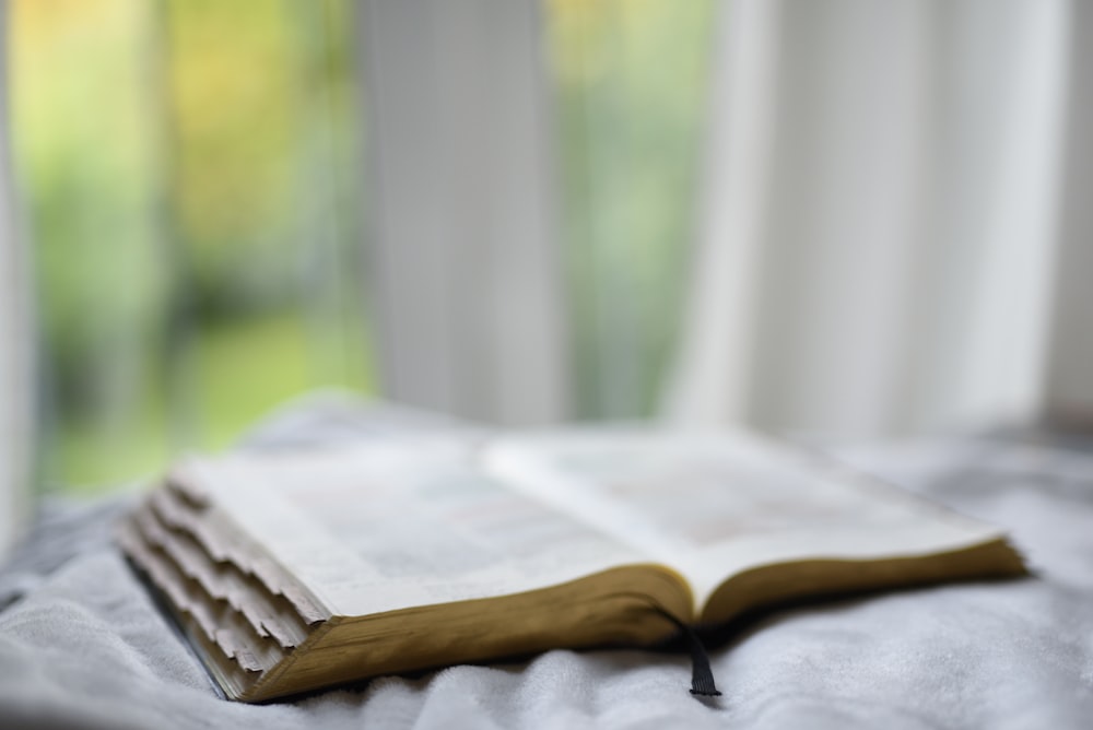 open book on gray textile