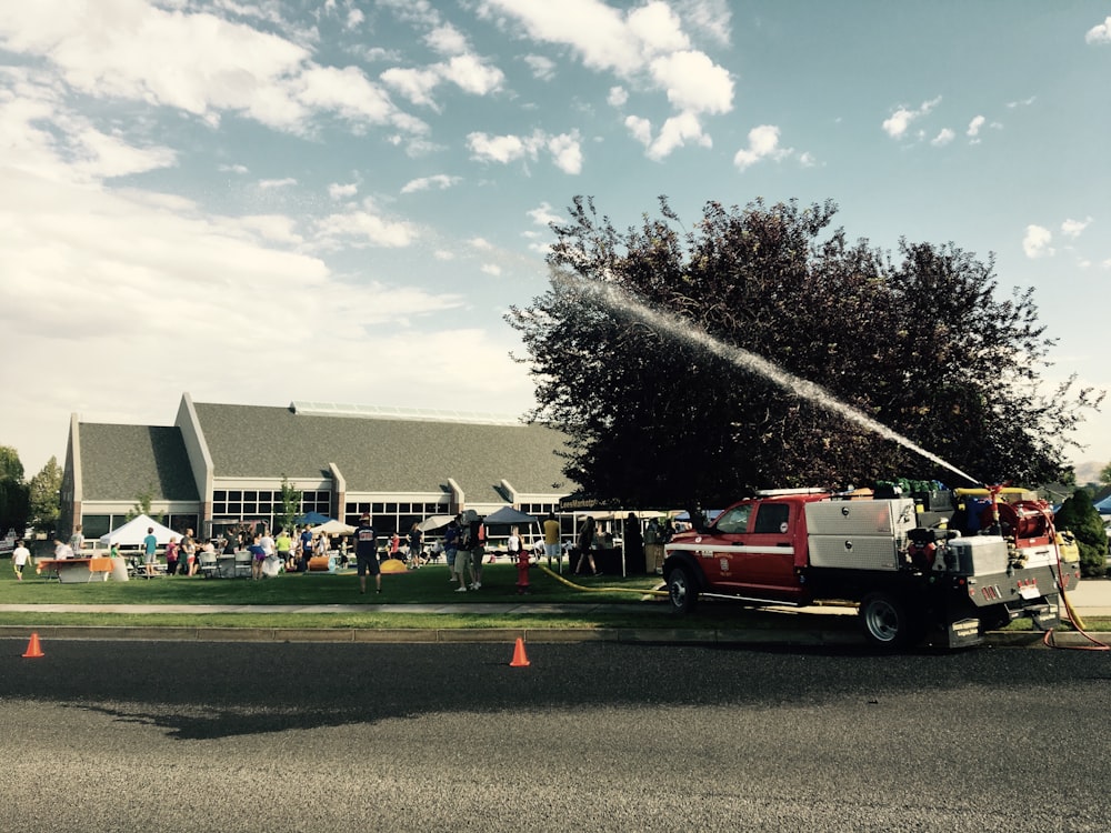 Red fire truck blowing water in a building during daytime photo