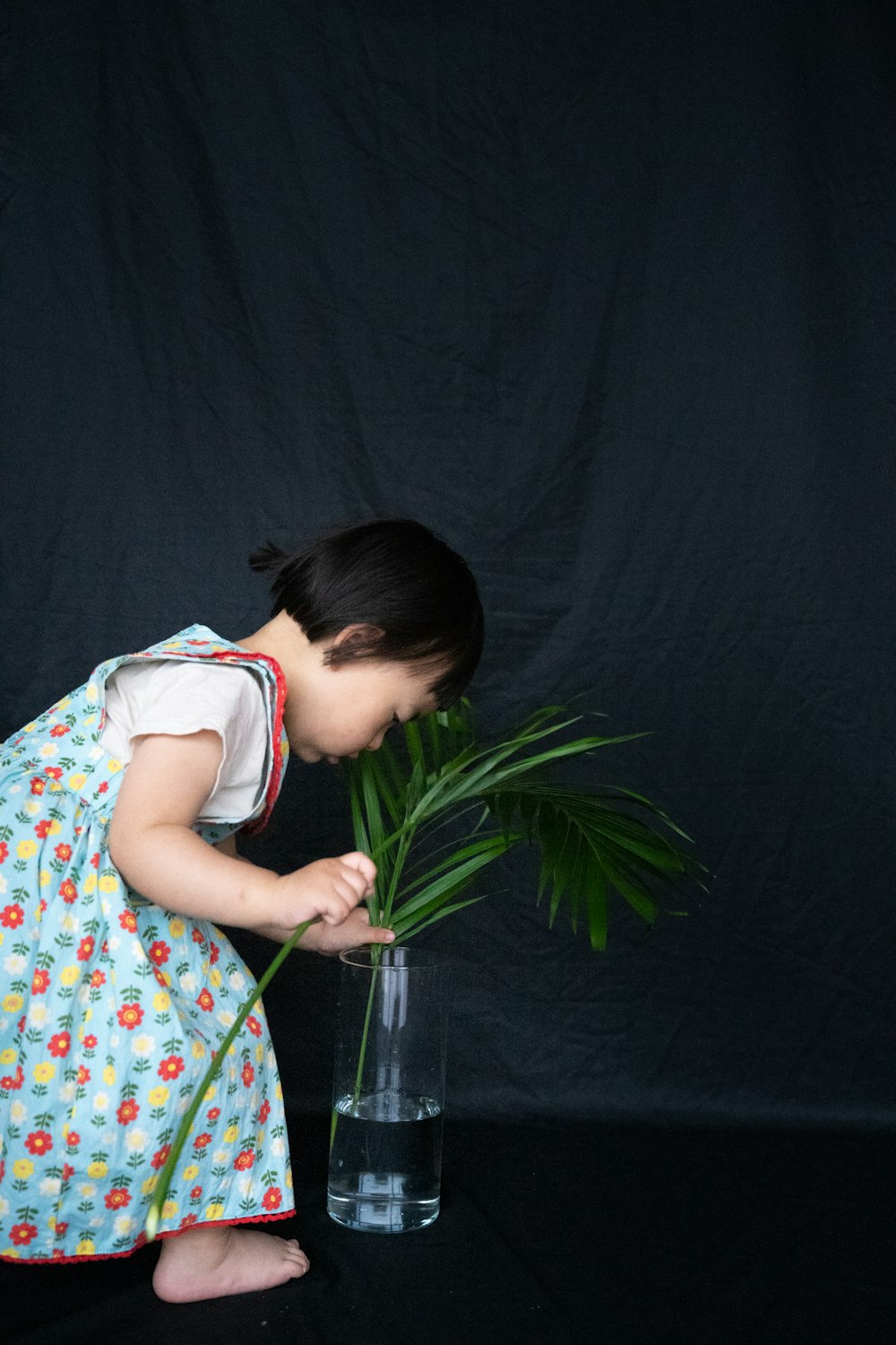 girl in blue,red,and yellow floral sleeveless dress