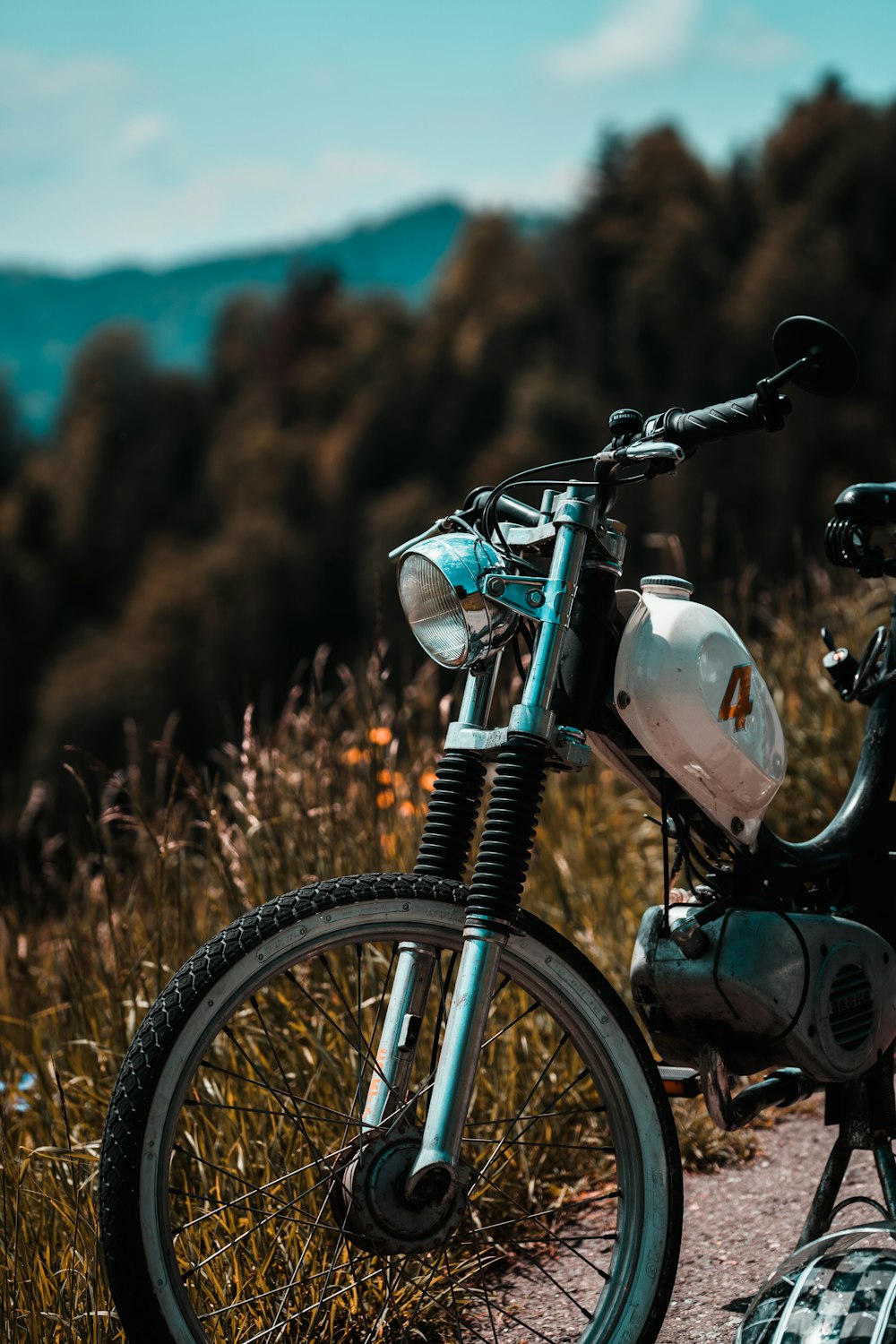 white pedal moped near plants