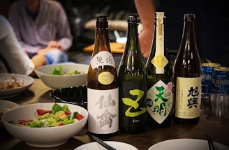 four assorted-labeled bottles beside bowls