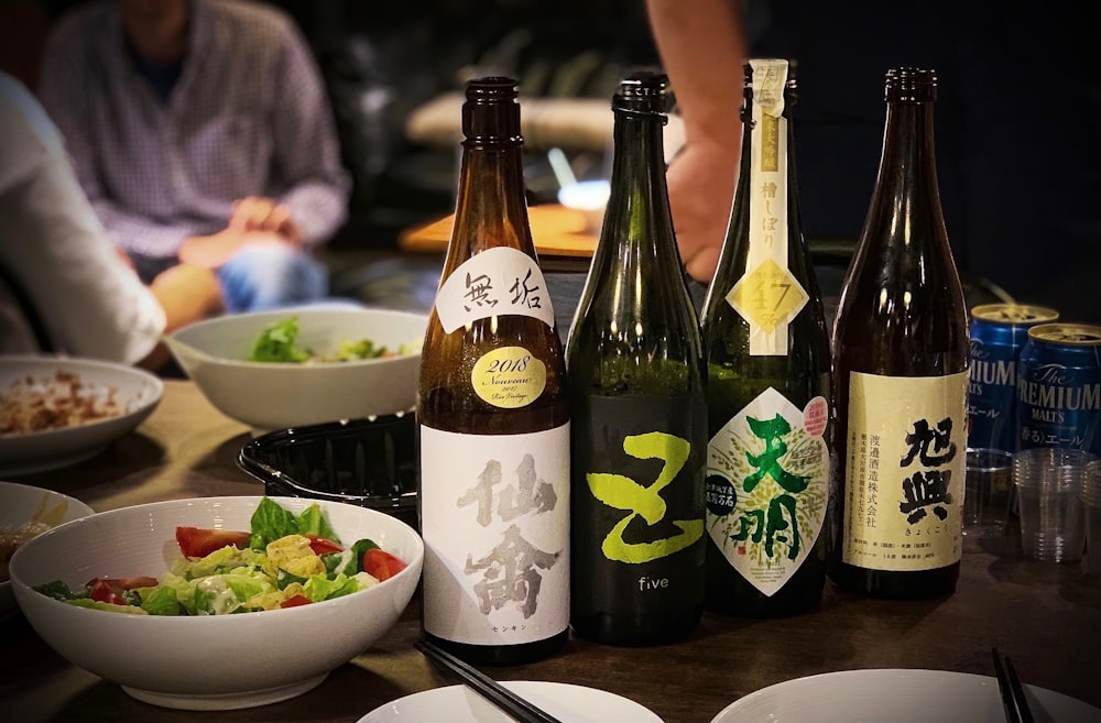 four assorted-labeled bottles beside bowls