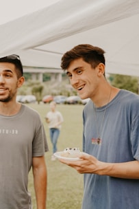 Cheerful catering staff serving guests at an outdoor event with warm smiles.