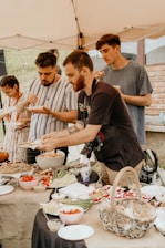 A diverse group of people sharing a meal in a community garden.