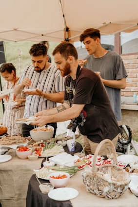 A diverse group of people sharing a meal in a community garden.