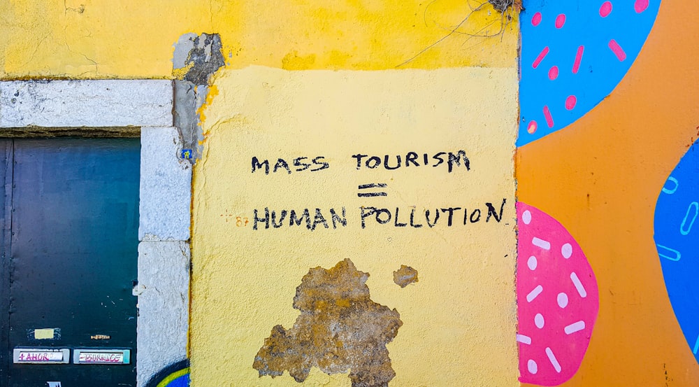 a sign on a wall that says mass tourism is human pollution