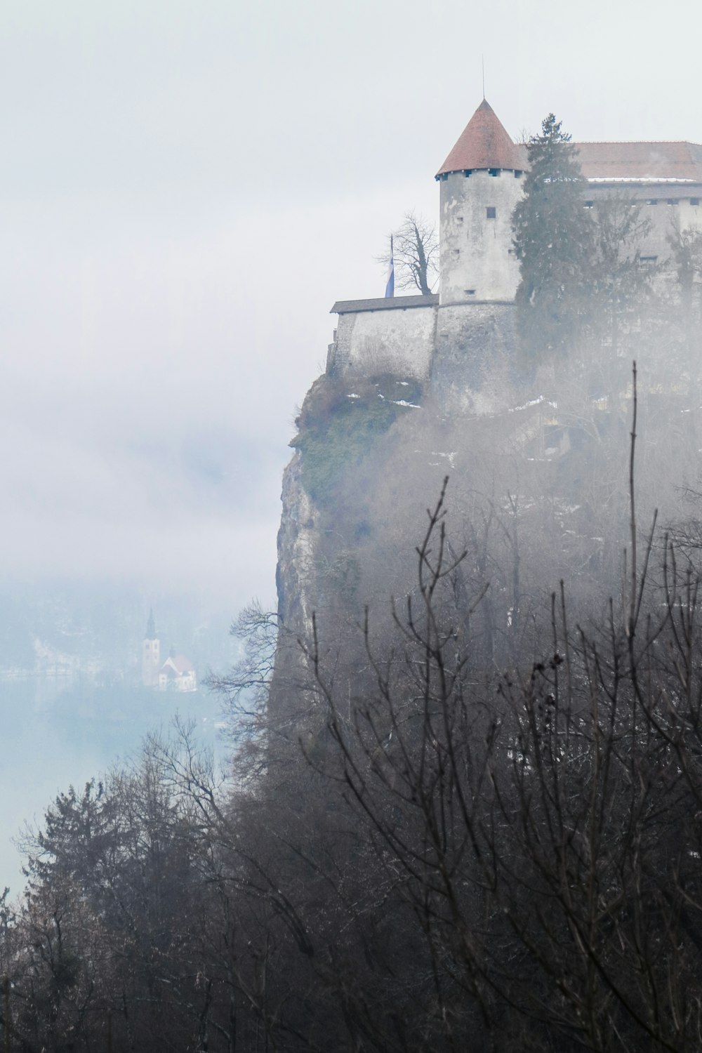 white concrete castle on hill during fogs