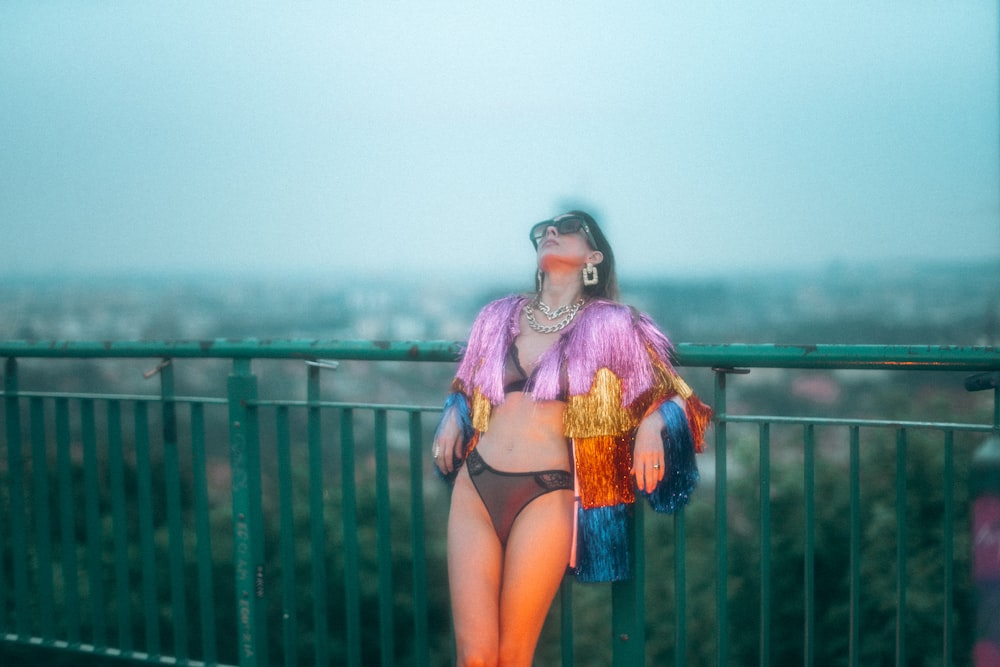 woman wearing bikini leaning on railing during daytime