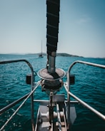 3D printed custom winch handle resting on a blue sailboat cockpit with Ionian islands in the background