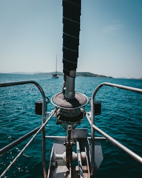 3D printed custom winch handle resting on a blue sailboat cockpit with Ionian islands in the background