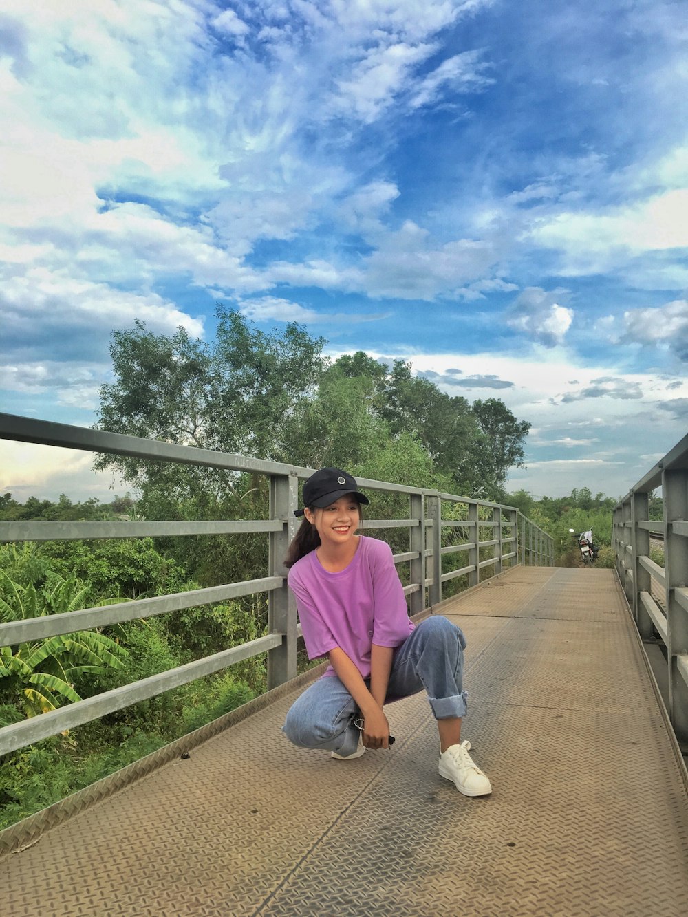 kneeling woman on bridge