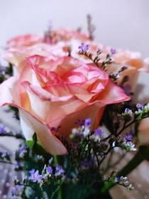 Close-up of delicate pink roses intertwined with fresh greenery, showcasing intricate floral design.
