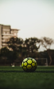 yellow and black soccer ball on field during daytime