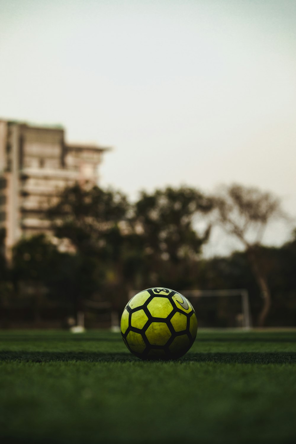 Balón de fútbol amarillo y negro en el campo durante el día