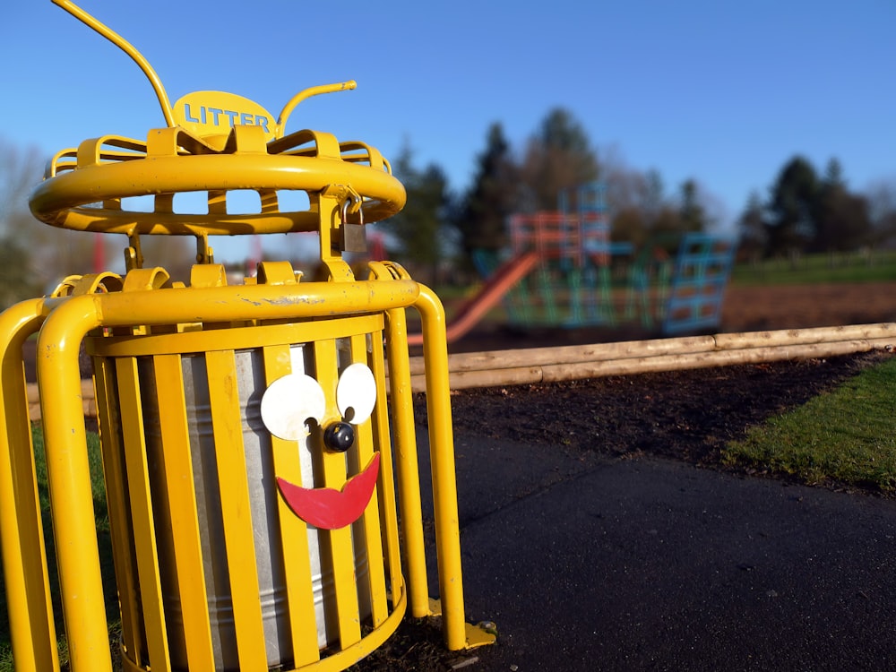 yellow metal Litter cage with smiley on gray surface