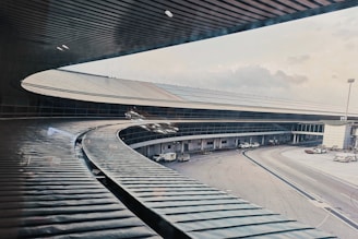 Modern airport terminal under construction with cranes and steel framework visible.