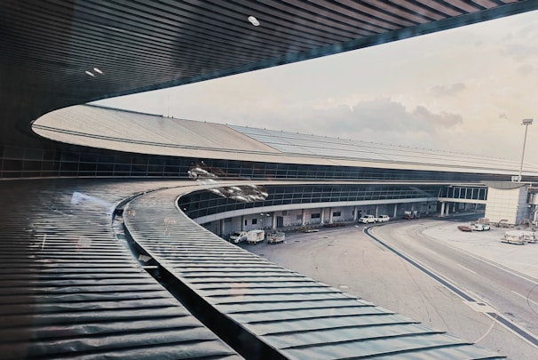 Modern airport terminal under construction with cranes and steel framework visible.