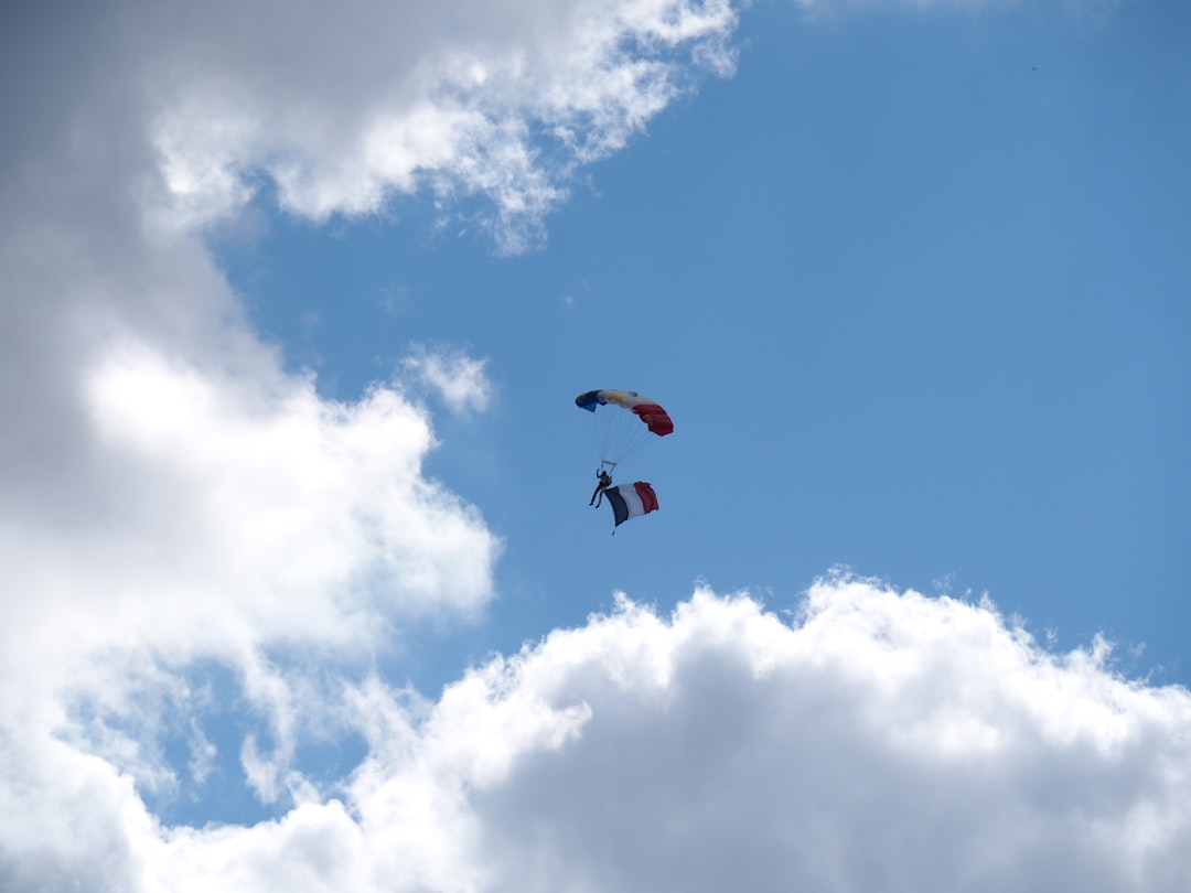 man parachuting near clouds