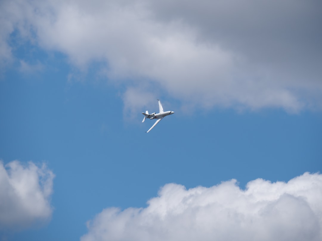 white airplane under blue and gray sky