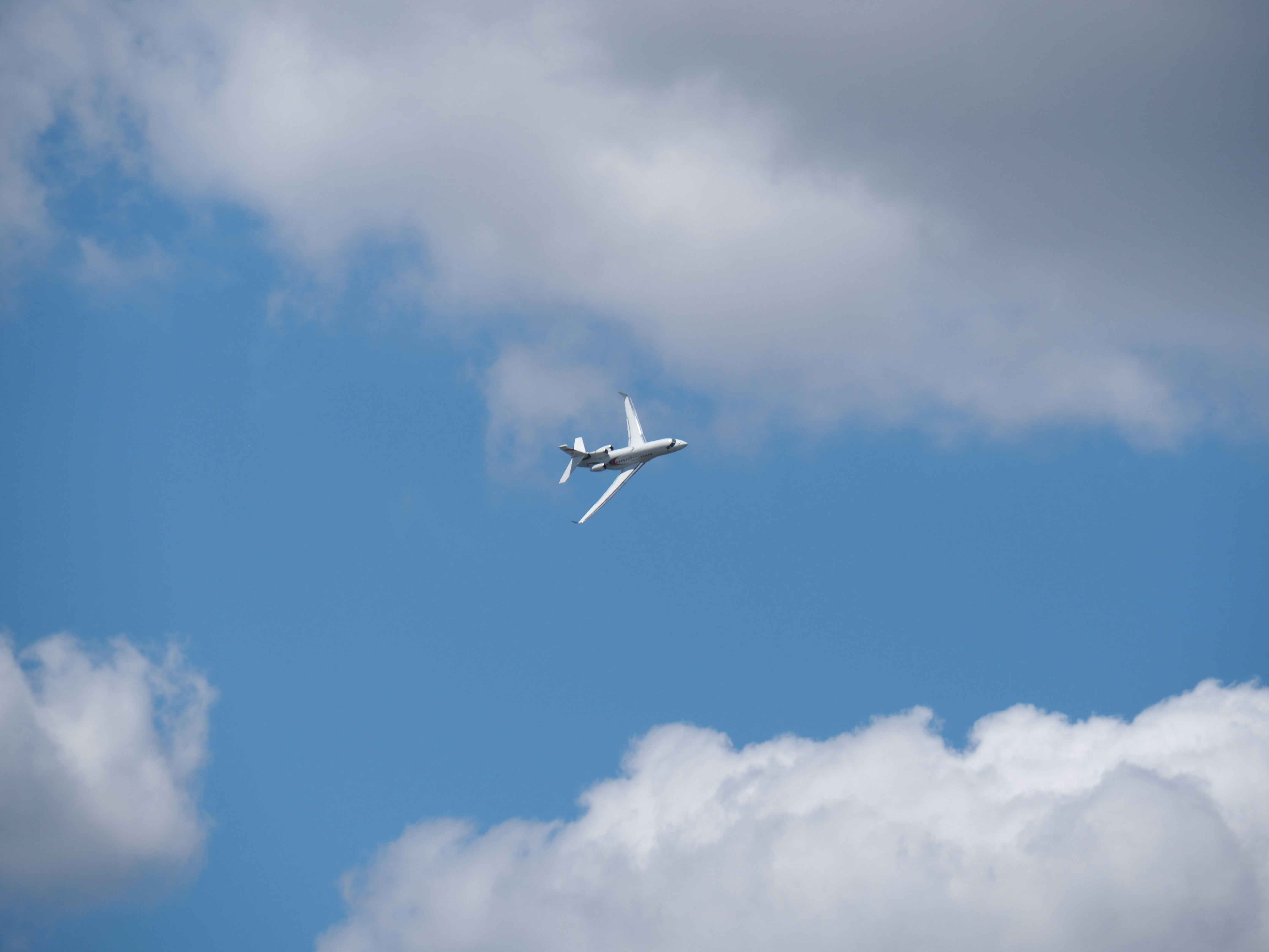 white airplane under blue and gray sky