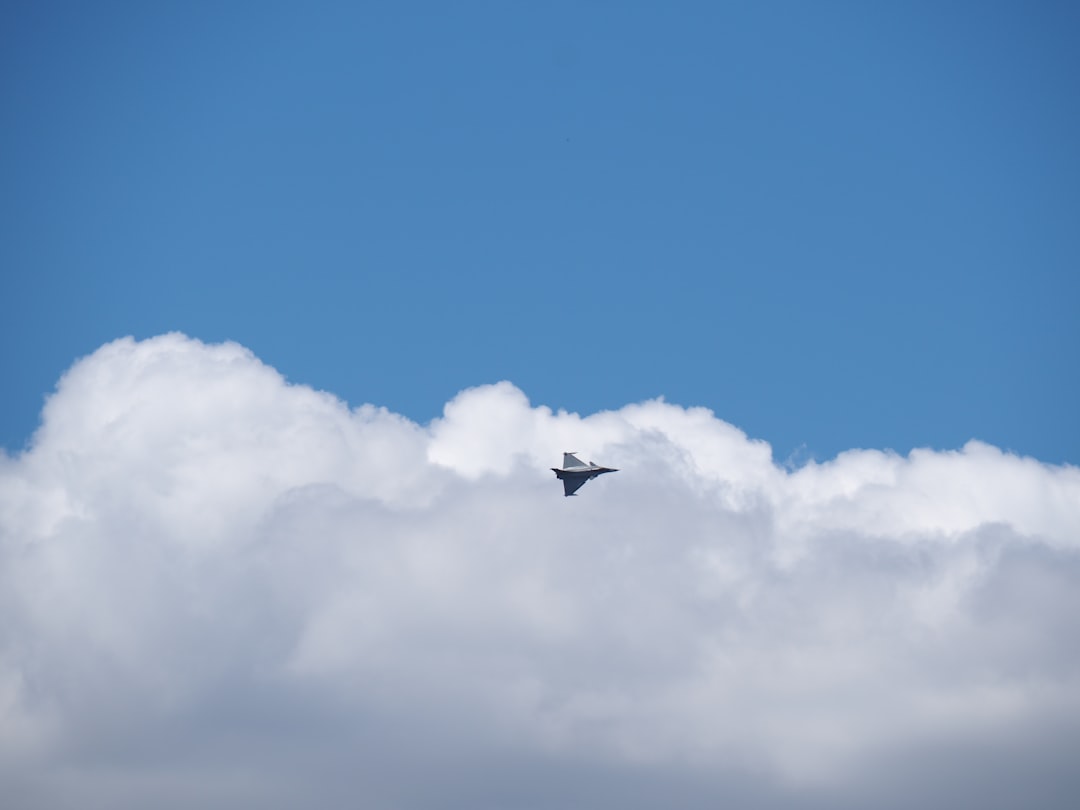 fighter plane flying near clouds