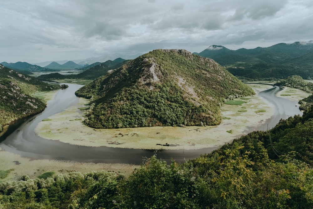 landscape photo of mountain surrounded with body of water during daytime