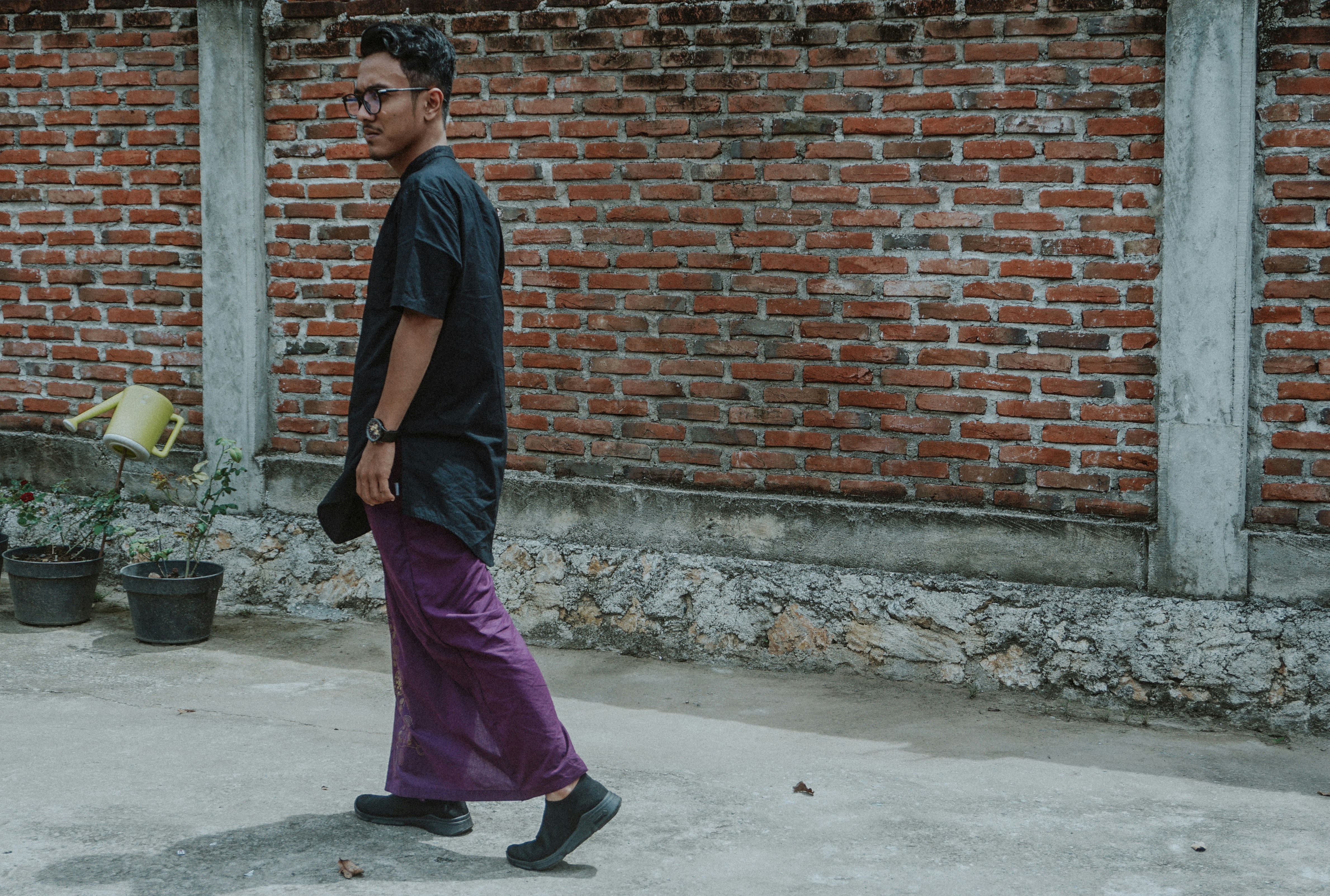 Pria berjalan di dekat tembok