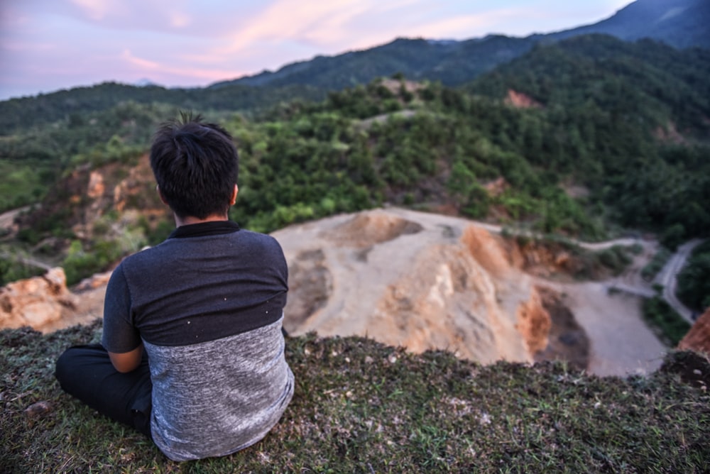 sitting boy overlooking mountains