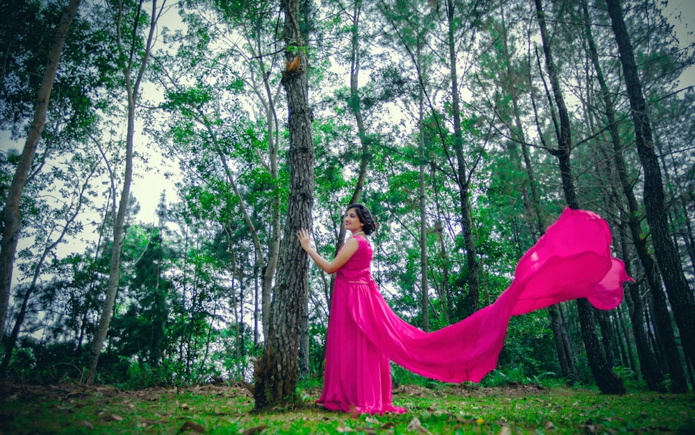 woman standing near outdoor while touching tree during daytime