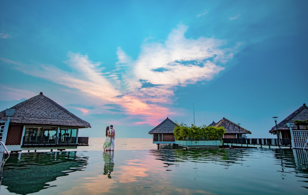 man and woman standing beside beach