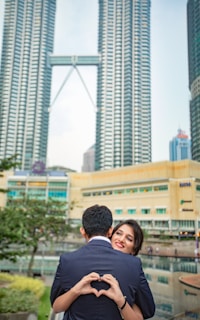 Happy couple taking a selfie with Singapore's iconic Gardens by the Bay in the background.