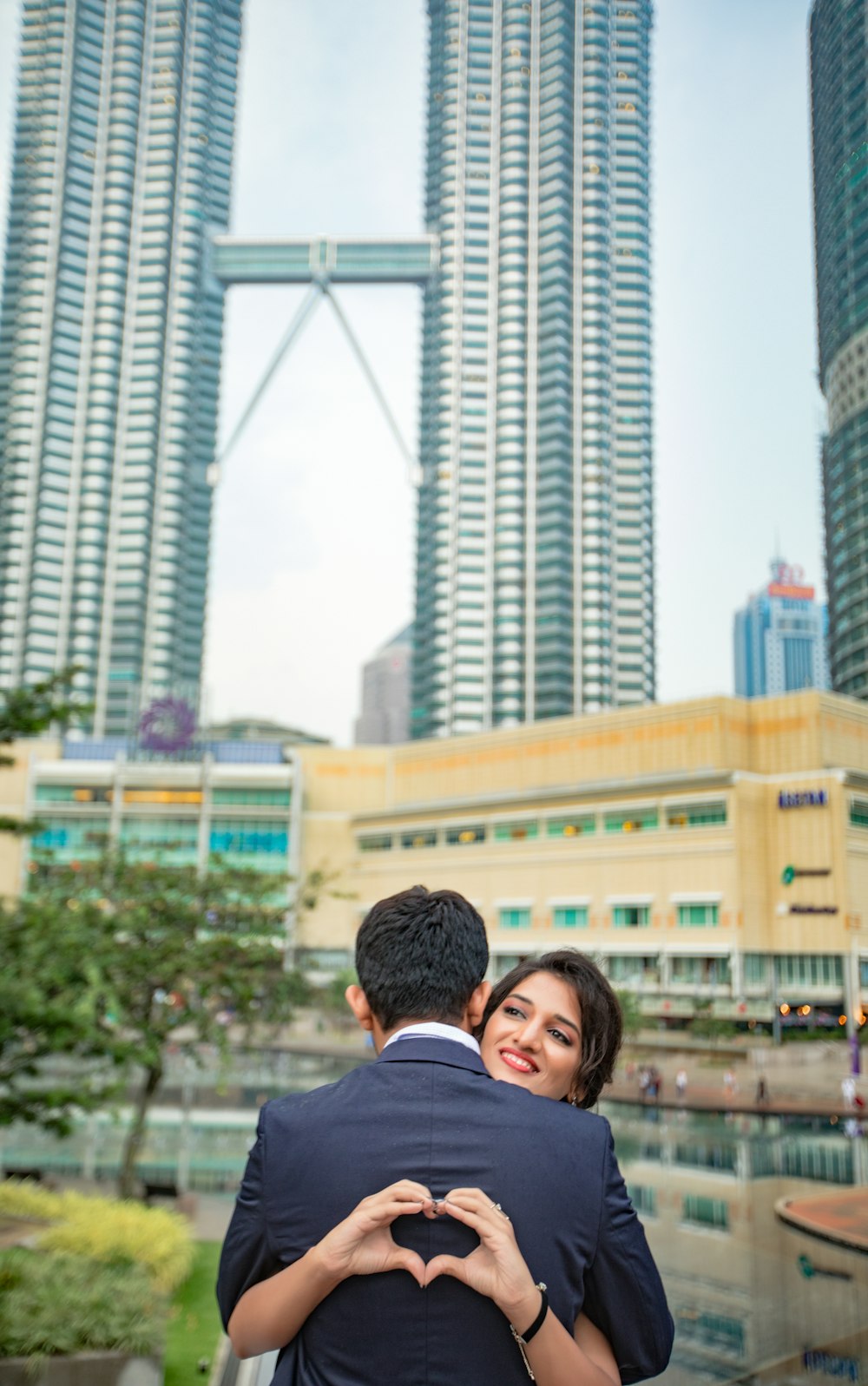 man hugging woman near Petronas Towers, Malaysia