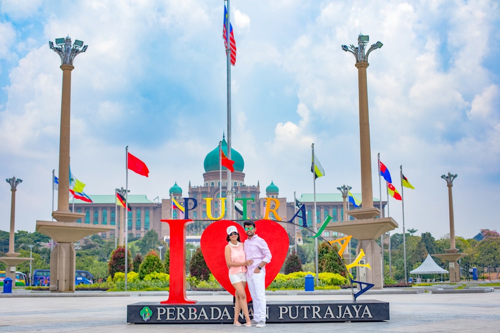 man and woman standing beside Putrajaya standee