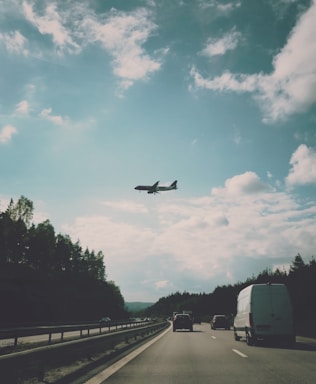 A truck transporting vehicles on a highway under a clear sky.