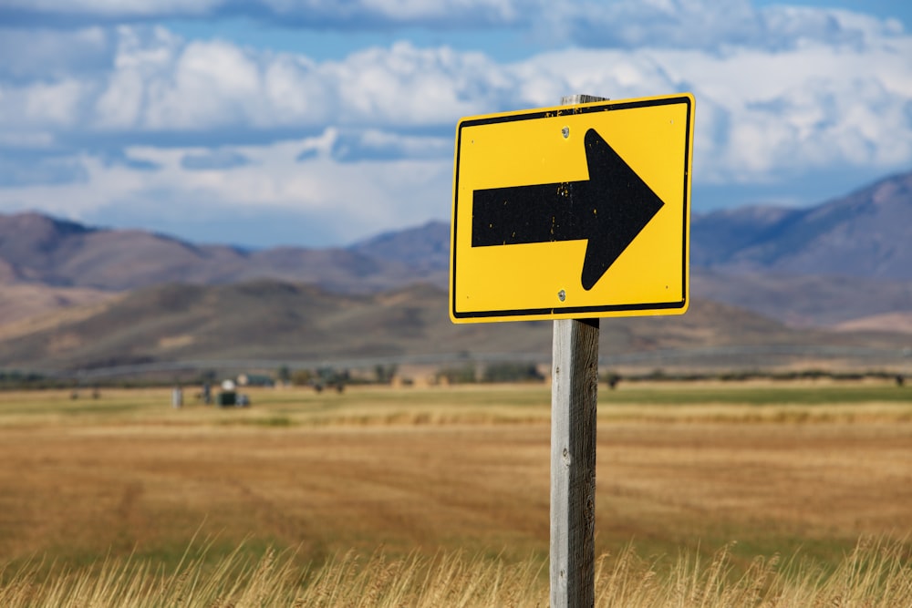 yellow arrow signage on focus photography