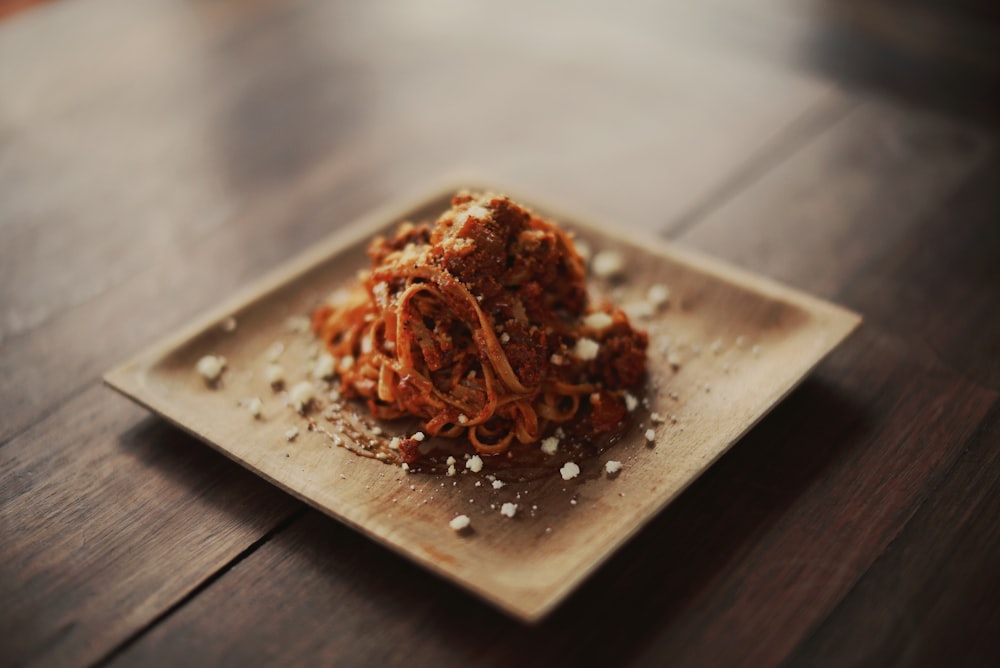 spaghetti served on brown plate